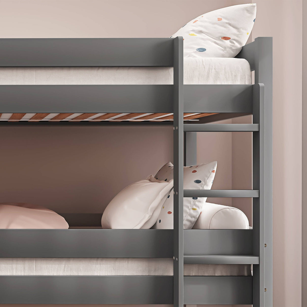 Side view of grey triple bunk bed showing upper and middle bunks. Wooden frame with safety rails and ladder for easy climbing.