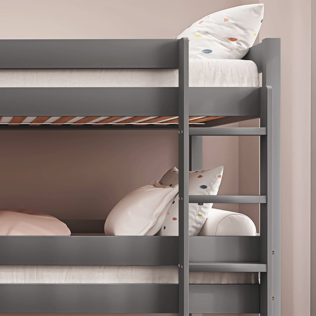 Side view of grey triple bunk bed showing upper and middle bunks. Wooden frame with safety rails and ladder for easy climbing.