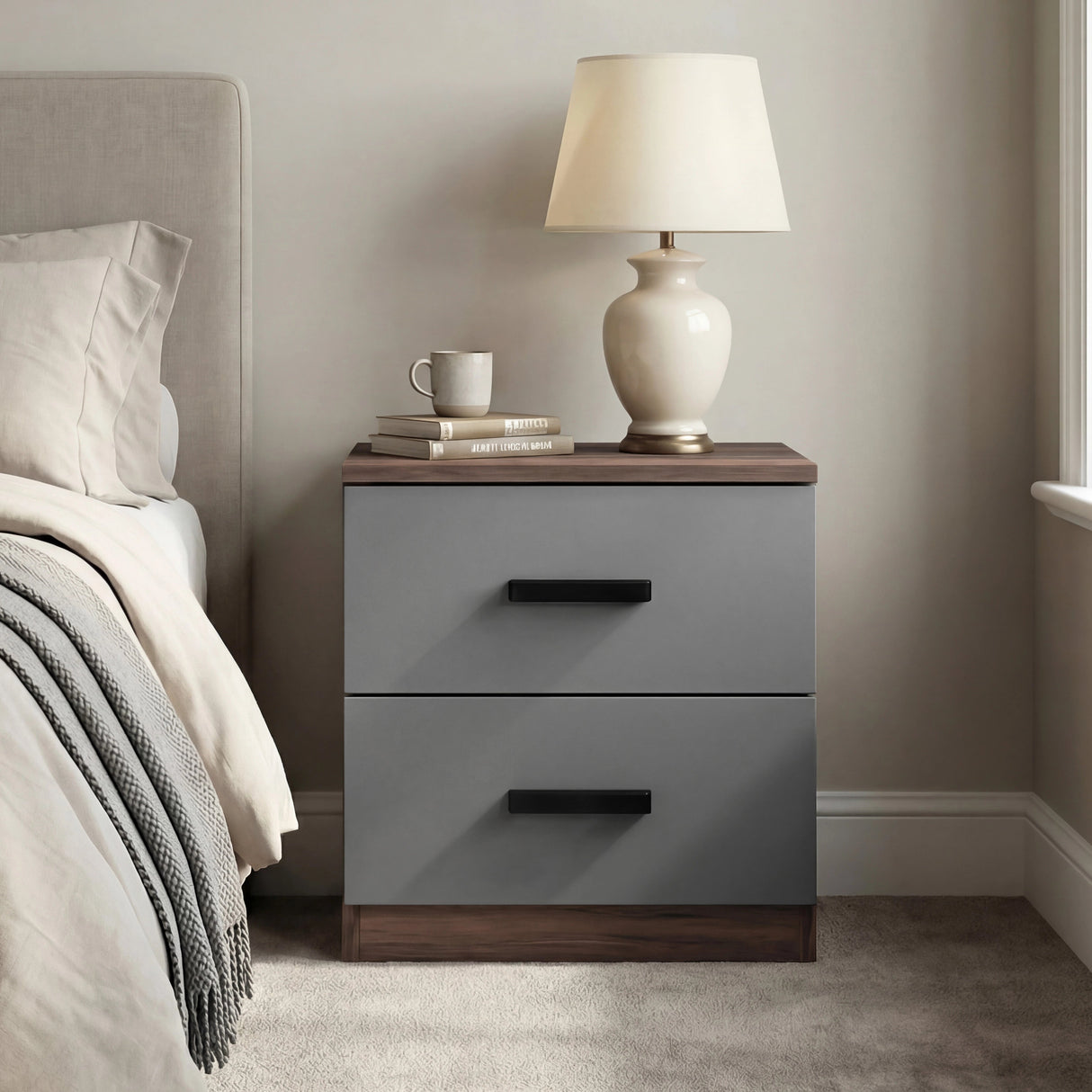 Walnut grey two drawer bedside table placed beside bed with dual tone cabinet finish and black wooden handles