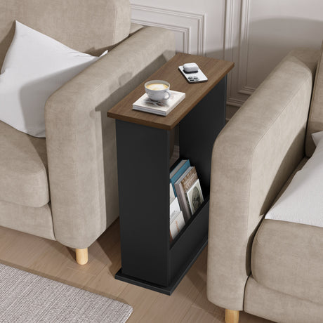 Black side table with a cup of coffee and books between two beige armchairs.