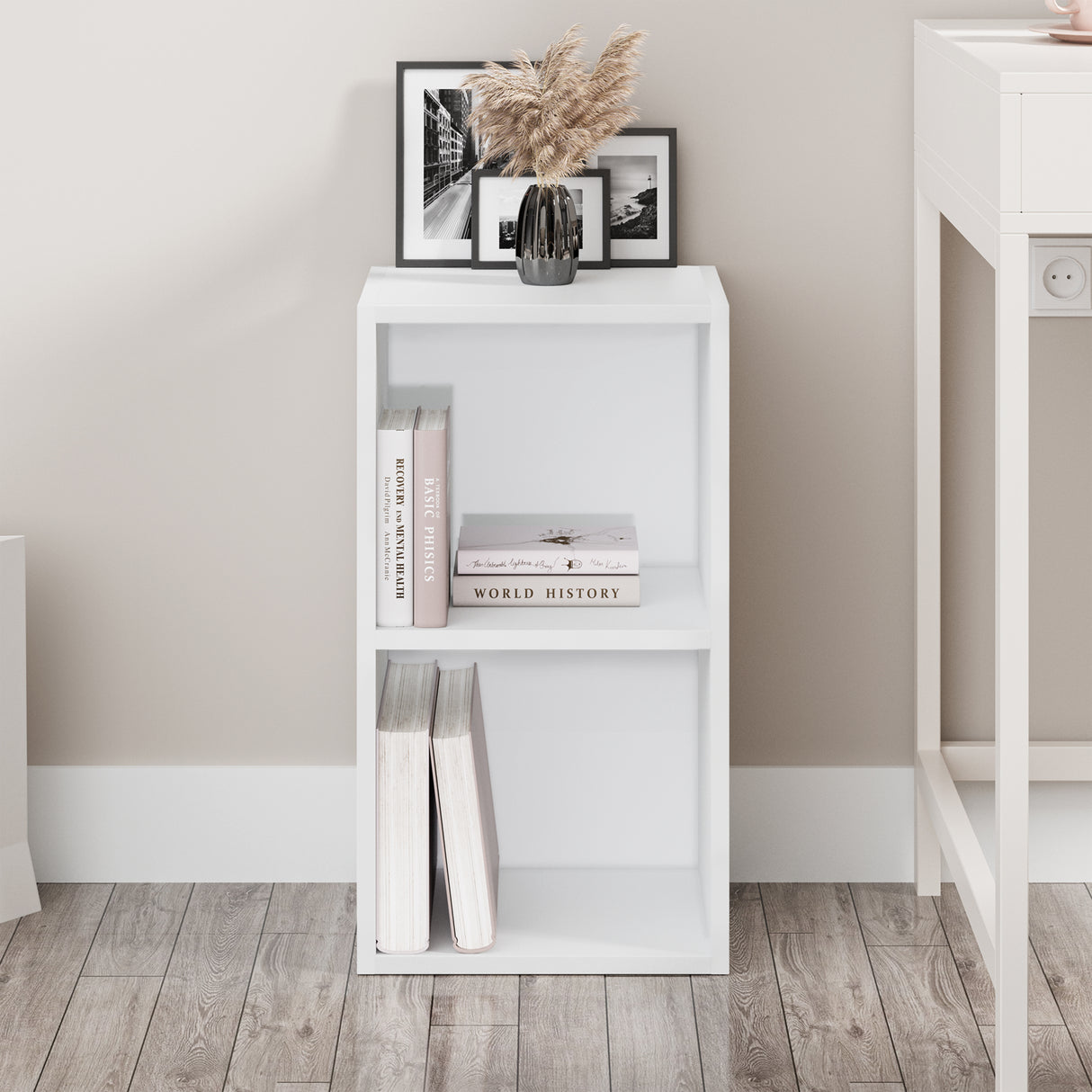 front view of compact white bookcase shown front-facing, styled with books and ornaments to add charm to any nook