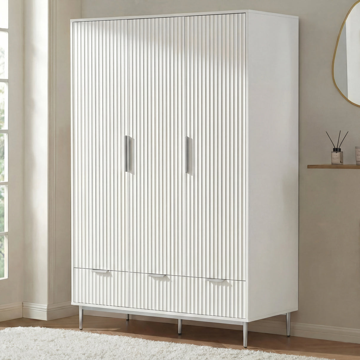 White three door wardrobe with lower drawers placed in room setting with soft neutral decor