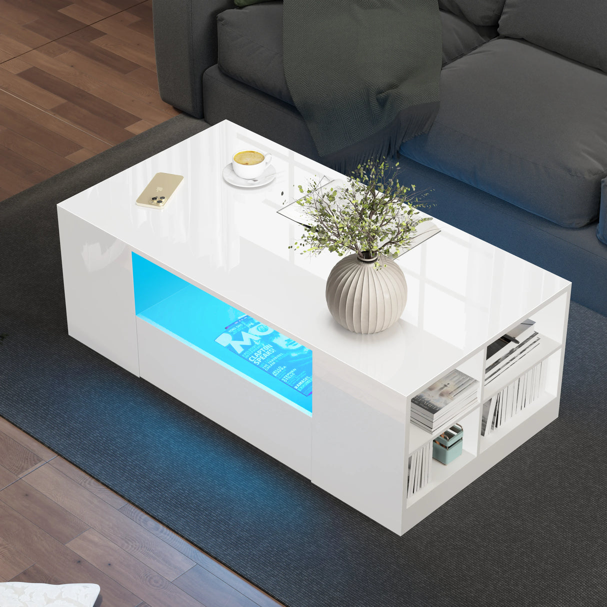 LED coffee table with storage drawers in high gloss white finish, featuring blue LED lighting and open shelving for books and decor in a modern living room.