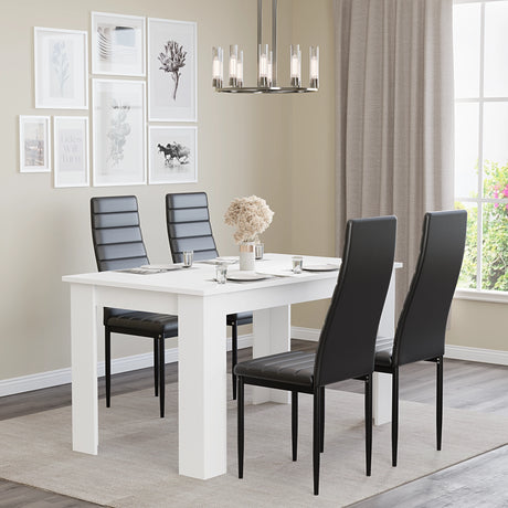 White dining table set for 4 with black leather chairs, styled in a modern dining room with wall art and chandelier. Perfect for small families.