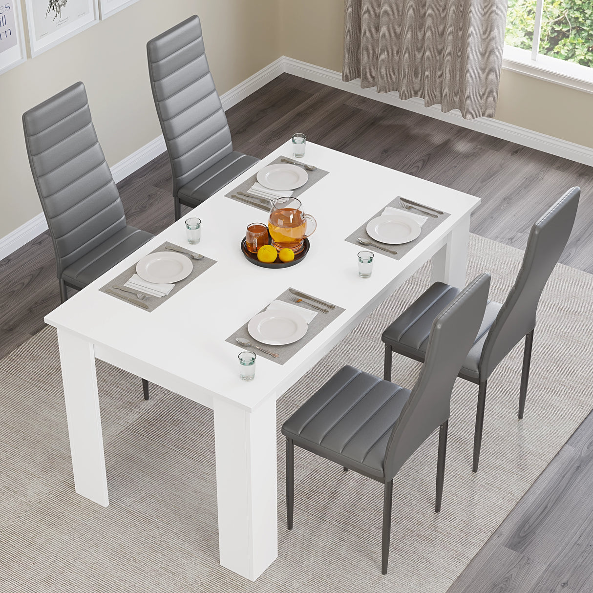 Overhead view of white dining table with grey chairs set for four. Ideal for modern kitchens or small dining rooms.
