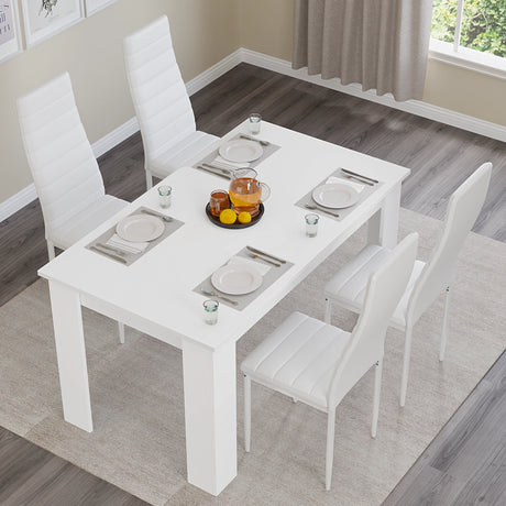 Top view of white dining table set with white PU leather chairs for 4. Perfect for minimalist kitchen or dining areas.