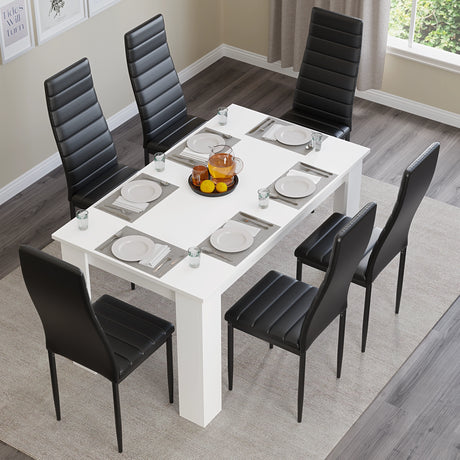 Top view of 6-seater white dining table with black chairs, set for a full meal. Perfect for modern dining rooms or kitchens.