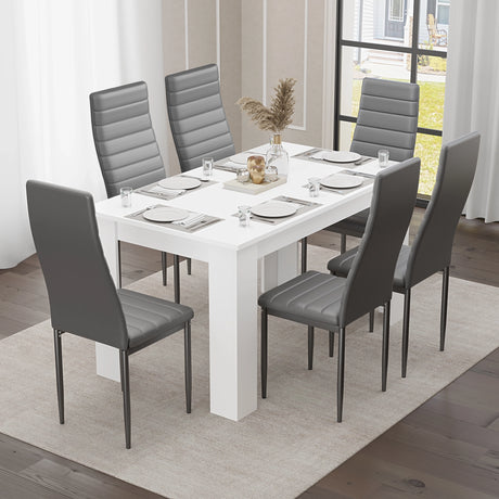 Modern white dining table paired with six grey chairs, creating a stylish and functional space for family dining."