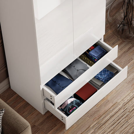 Open drawers of white high gloss wardrobe filled with folded clothes. Space-saving bedroom furniture with modern drawer organization.