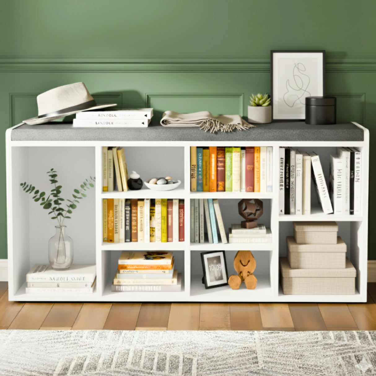 White bookshelf with books, decor items, and a green wall background