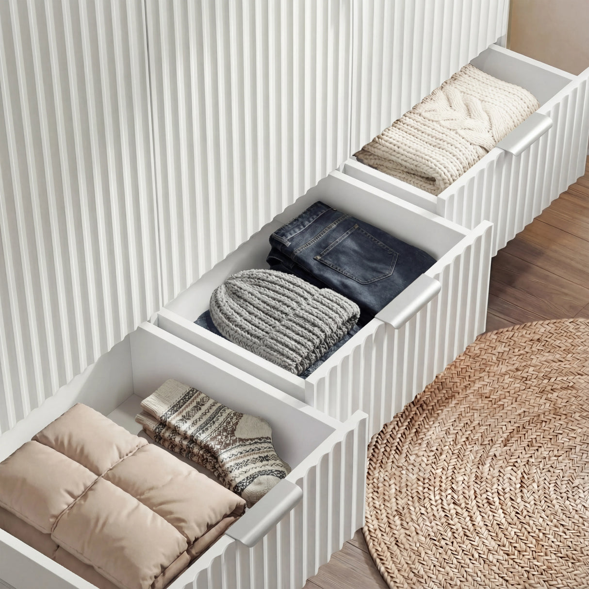 White wardrobe three drawer storage sections showing internal organisation and a stack of clothes