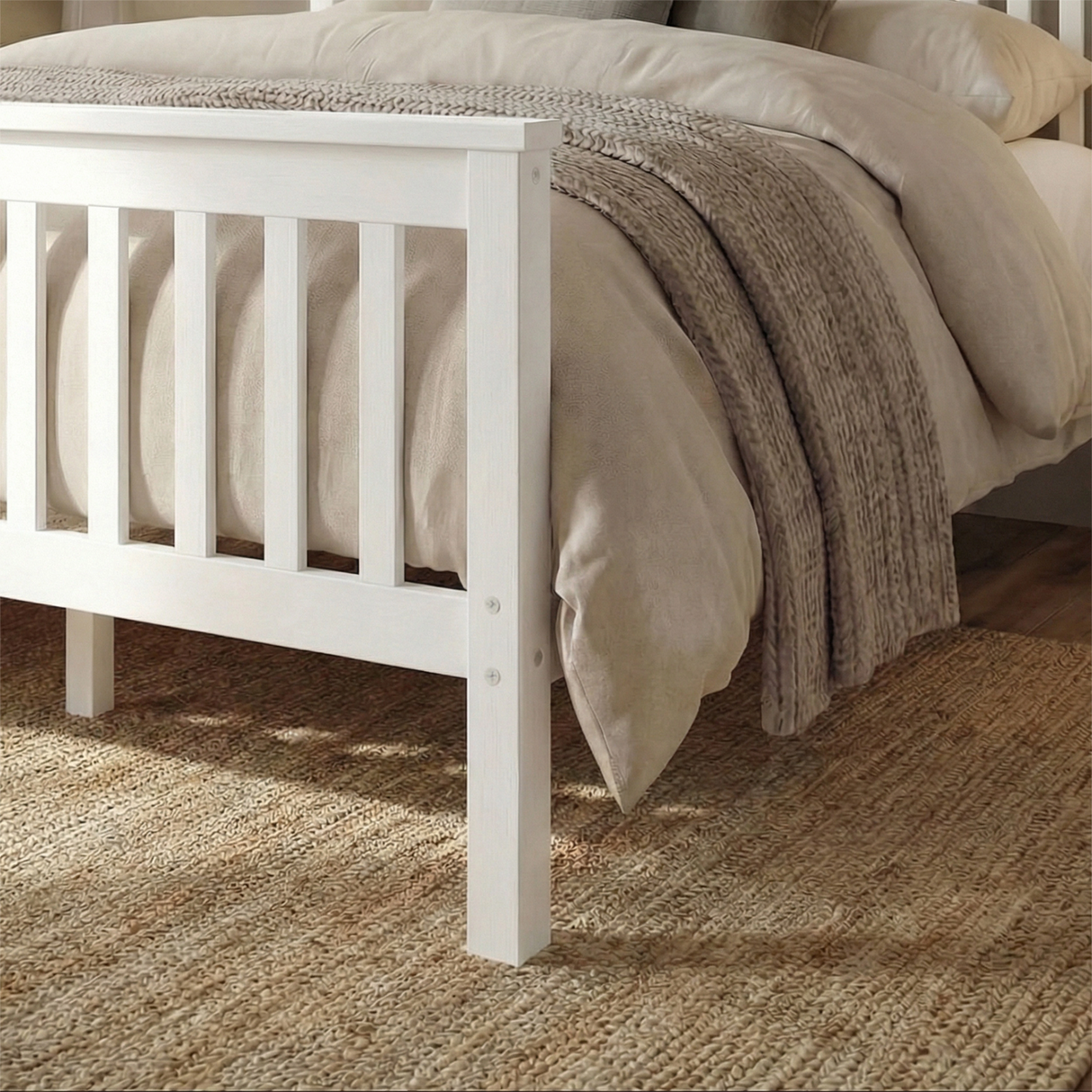 Close up view of white wooden double bed frame slatted footboard with beige bedding on a wooden floor