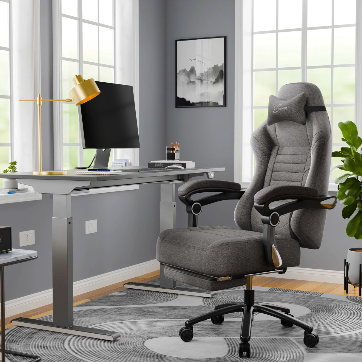 A grey office chair in a modern office setting with a desk and lamp.