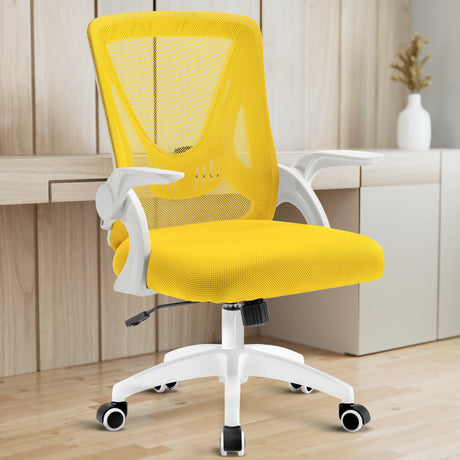 A yellow mesh chair in a home office provides ergonomic support, with a working desk in the backdrop.