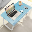 Portable folding laptop desk in blue with height adjustable legs, built-in cup holder, and space for mouse and phone, ideal for bed or floor use.