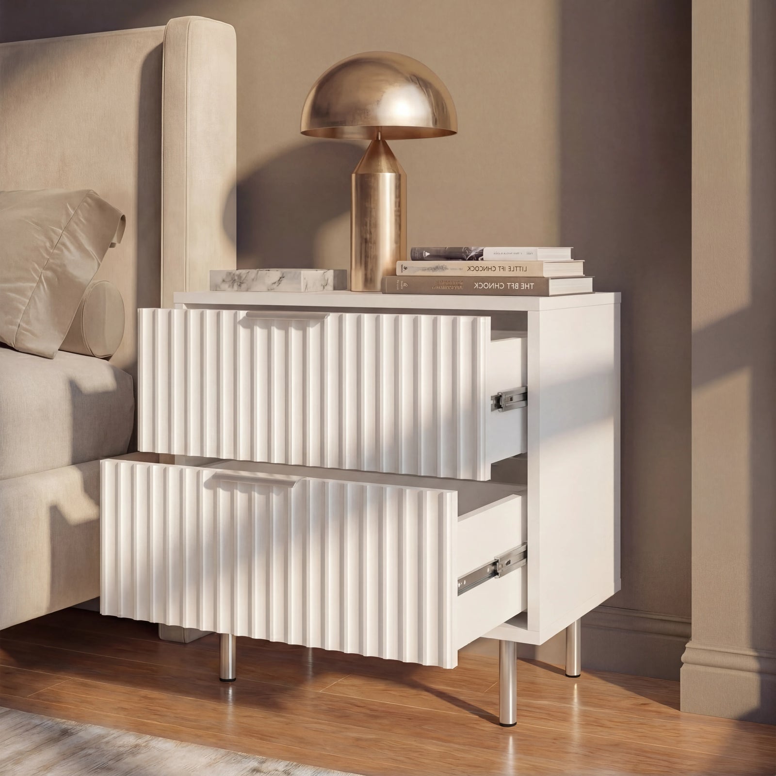 [White] Bedside table beside a bed, shown with two drawers partially open in soft natural lighting