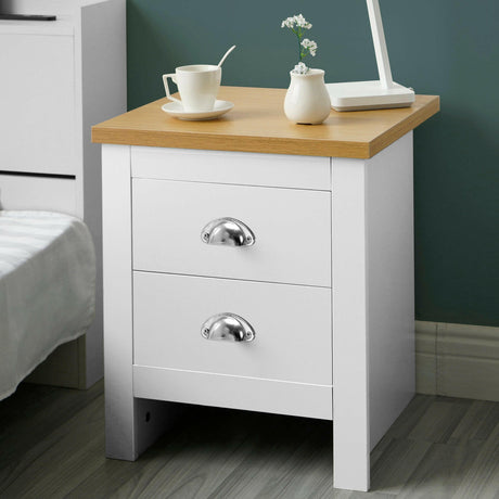 2 drawer bedside table with a top surface holding books and a lamp, perfect for a modern bedroom.