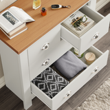 Open drawer view of white shaker chest showing neatly folded clothes and accessories, highlighting drawer depth and use.
