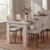 Modern 4 seater white dining table set with white PU leather chairs in a bright kitchen, ideal for small dining spaces.