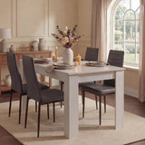 Dining room with a white table set for four, gray chairs, and decorative elements.