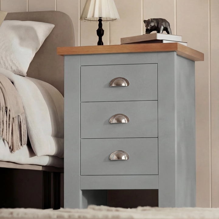 [Grey] Three-quarter angled view of shaker bedside table showing side panel and cup handles beside bed
