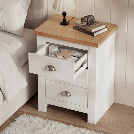 [White] Top drawer pulled open showing internal storage depth with everyday bedside items