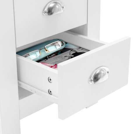 White 3-drawer bedside table with drawers open , holding glasses and accessories, modern design.