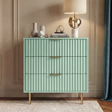Green flutrina 3 chest of drawers with gold handles and legs placed in a natural light room