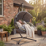 Round Garden Hanging Egg Chair outdoors with a person relaxing, showcasing its comfort and suitability for garden lounging and rest.