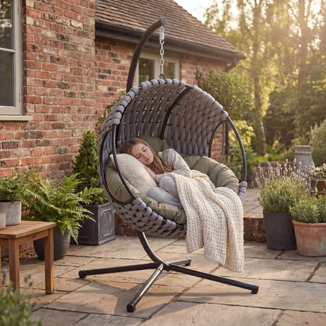 Round Garden Hanging Egg Chair outdoors with a person relaxing, showcasing its comfort and suitability for garden lounging and rest.