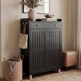 [Black] Front view of shoe cabinet with both slatted doors closed and decorative vase with bowl on top