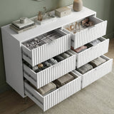 [White] chest of drawers with decorative items against a green wall placed in a natural light room
