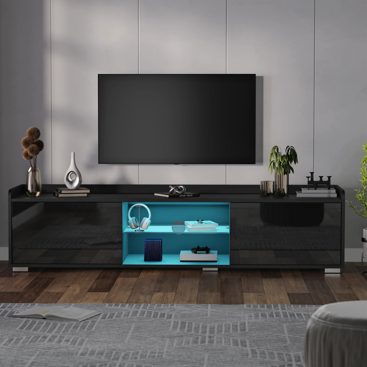 Modern black TV stand with a blue illuminated shelf in a living room setting.
