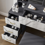 Close-up of marble-effect drawers on grey dressing table. Organized makeup and skincare storage in a modern vanity table with mirror and stool.
