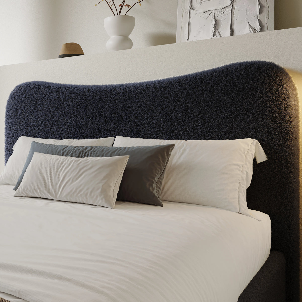 Curved headboard ottoman storage bed in boucle fabric with navy blue finish. Features plush upholstery and hidden storage, ideal for modern bedrooms.