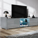 Modern TV stand with a television on a wooden floor in a room.