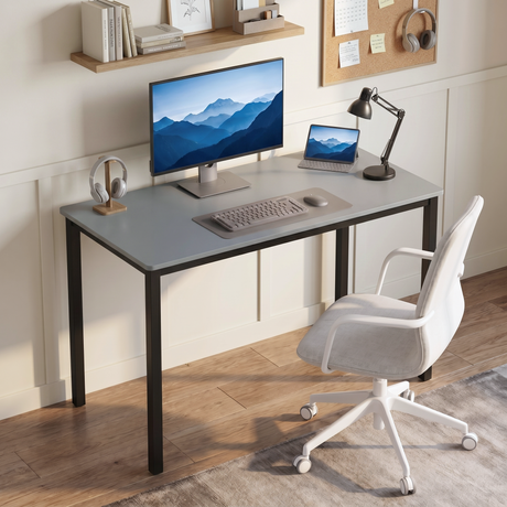 [100 X 50 cm] Office Desk styled in a sunlit room with monitor, tablet, keyboard, anglepoise lamp, headphones stand, white swivel chair, and corkboard