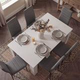 Top view of modern 6 seater white dining table set with grey chairs, styled with neutral tableware and candles for elegant dining.