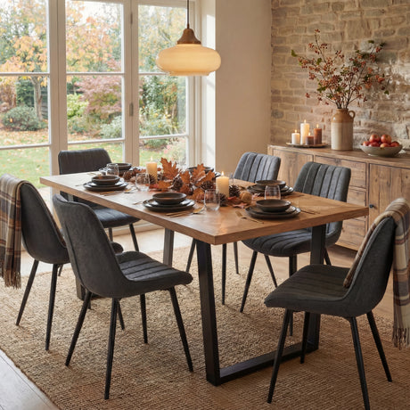 Aldridge dining set with 6 grey chairs surrounding a wooden finish table, complete with plates, glasses and a autumn decor.