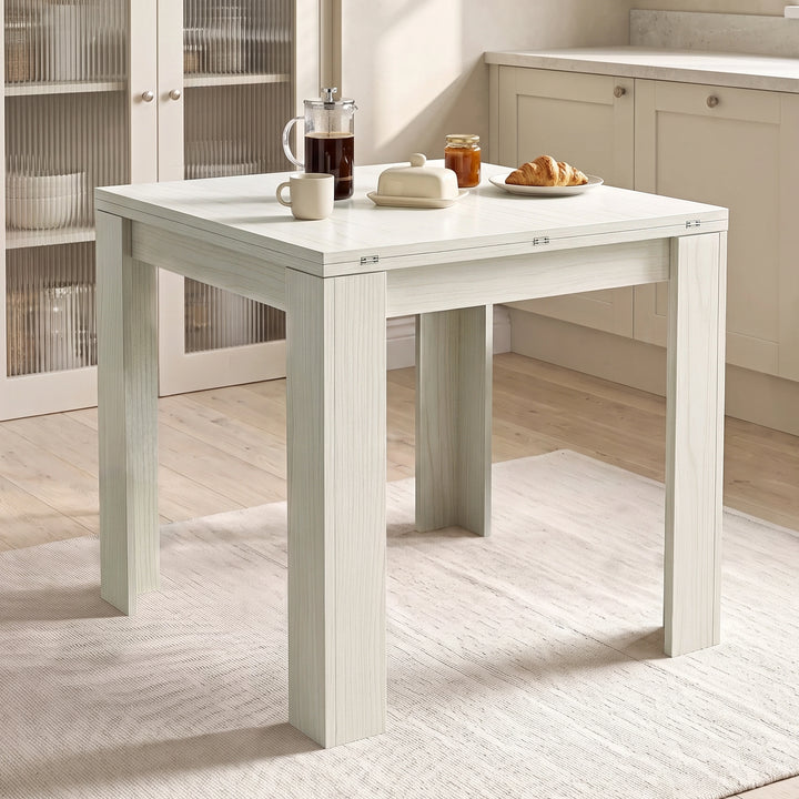 [Ash White] Closed square flip-top dining table with steel hinges, styled with a French press, mug, honey and croissant.