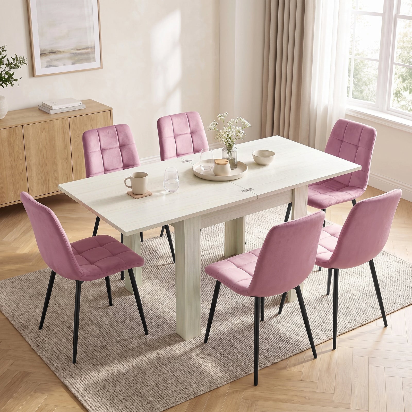 [Ash White] Extended flip-top dining table with six pink chairs and tableware in a bright open-plan kitchen diner.