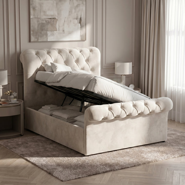 [Beige] Ottoman storage view with raised slatted base, black lift frame, folded bedding, and panelled wall