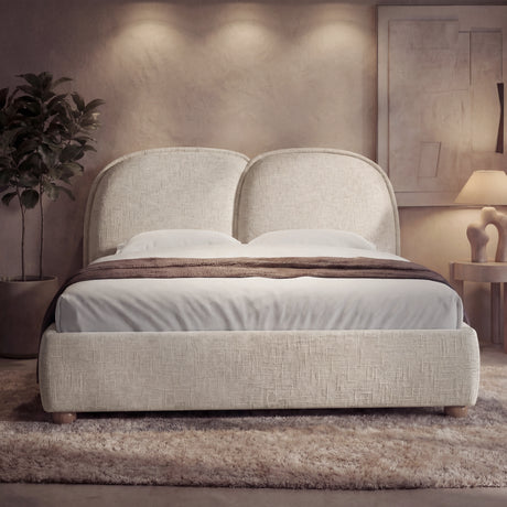 [Double | Beige] Upholstered beige double bed frame with a soft padded headboard and wooden legs in a low-light bedroom setting