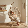 [Beige] Woman sitting in a hanging egg chair with a dog in a cozy room