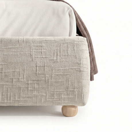 [King | Beige] Embracea base close-up showing geometric textured fabric and round natural wood feet detail