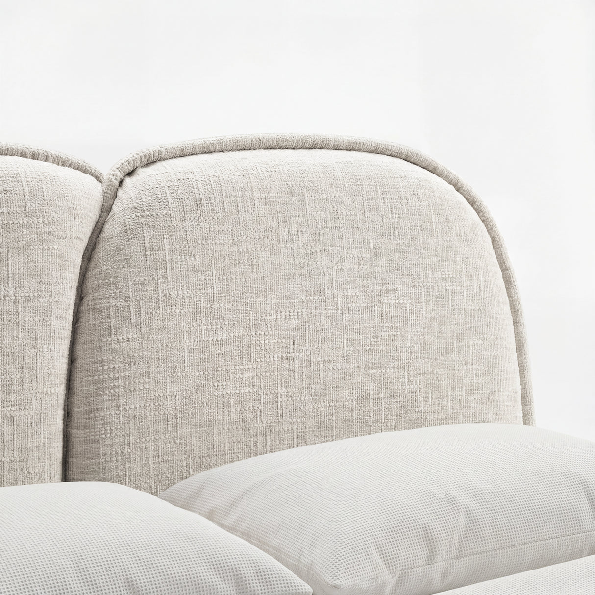 Close-up view of a beige upholstered headboard on a double bed frame with soft cushioning