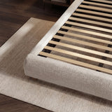 Angled detail showing the upholstered king-size bed perimeter with exposed wooden slats for the internal mattress support