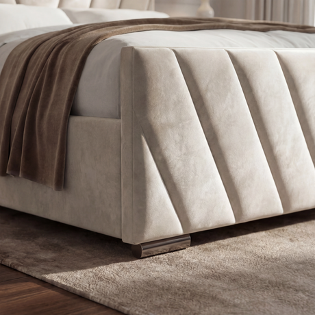 Detailed view of the bottom corner of the beige ottoman bed, showing its sturdy frame and elegant finish
