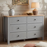 [Grey] Linra large 6 drawer chest front view with vase and table lamp on oak top with framed artwork above
