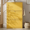 [Yellow]  Shaker Shoe Cabinet closed three-door flip-front unit in hallway setting with woven basket and staircase in background